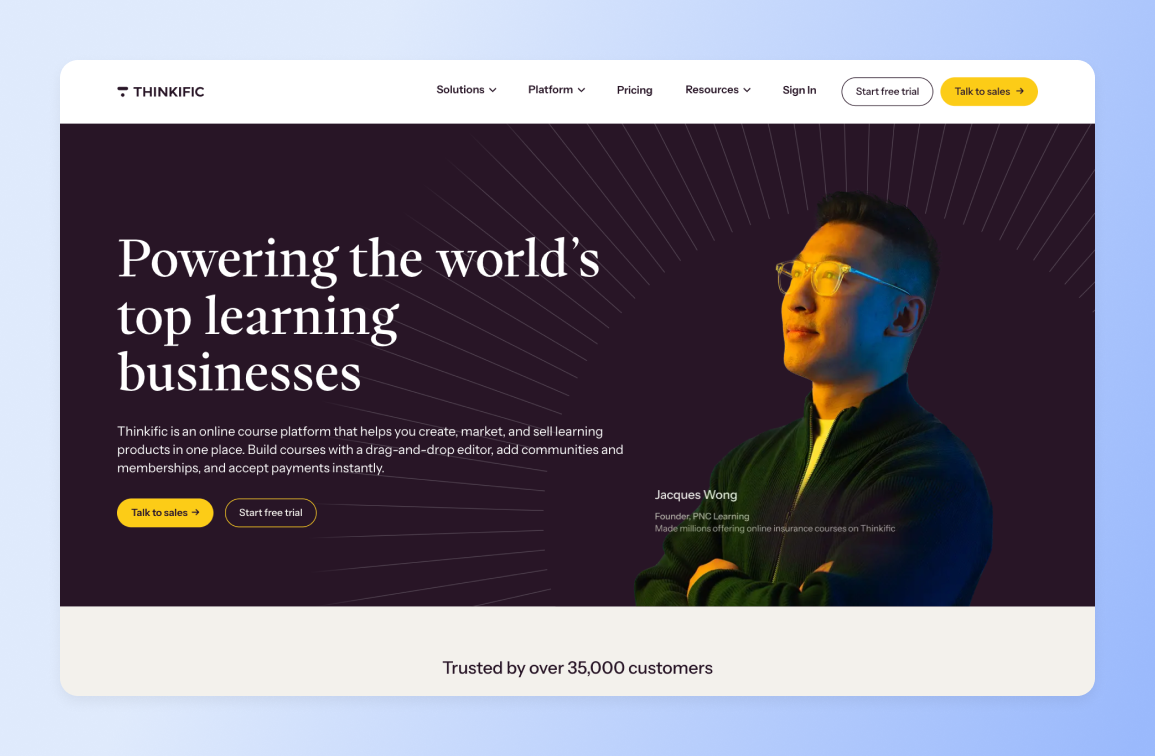 Thinkific homepage featuring Jacques Wong, Founder of PNC Learning, wearing yellow glasses against dark background with radiating lines and text "Powering the world's top learning businesses